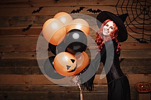 Halloween Witch Concept - Beautiful caucasian woman in witch costumes celebrating Halloween posing with posing with orange and bla