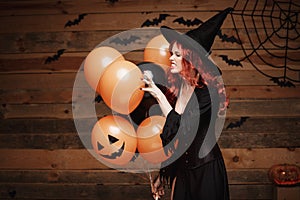 Halloween Witch Concept - Beautiful caucasian woman in witch costumes celebrating Halloween posing with posing with orange and bla