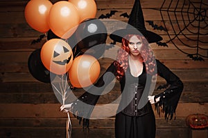 Halloween Witch Concept - Beautiful caucasian woman in witch costumes celebrating Halloween posing with posing with orange and bla