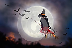 Halloween witch flying broom. Huge moon and bat