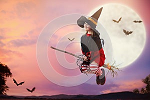 Halloween witch flying broom. Huge moon and bat