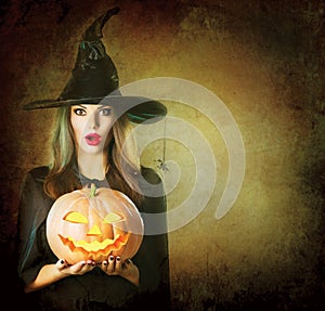 Halloween Witch holding carved pumpkin Jack Lantern