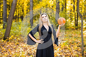 Halloween Witch with Pumpkin in a forest.