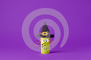 Halloween witch on purple for Halloween concept background. Paper crafts, easy DIY. Handcraft creative idea from toilet tube for