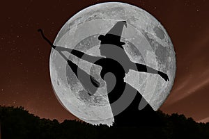 Halloween witch silhouette flying with broomstick. Full Moon.