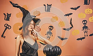 Halloween woman design. Halloween Witch with a carved Pumpkin and magic lights. Sexy Models Posing on Halloween
