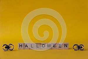Halloween wooden blocks with spiders on yellow background, Halloween background
