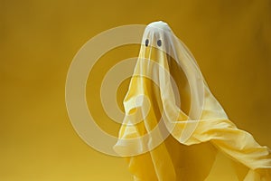Halloweens eerie grace white ghost sheet hovers in yellow space