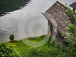 HALLSTATT, AUSTRIA - 06/16/2019: Small wooden cottage on the bank of the lake