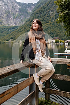 Hallstatt, Austria: Portrait of beautiful romantic young woman tourist smile, natural light, body positivity, girl in beige plaid