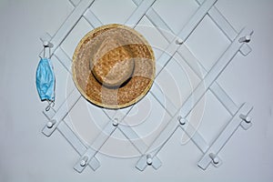 Hallway cloakroom with a protective mask and a straw hat