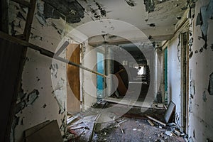 Hallway of desolation in abandoned building, peeling paint and debris speak of decay