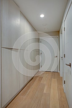 Hallway features ivory cabinets and taupe walls