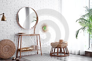 Hallway interior with big round mirror, table and decor