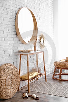 Hallway interior with big round mirror, table and decor