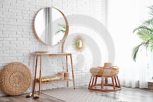 Hallway interior with big round mirror, table and decor