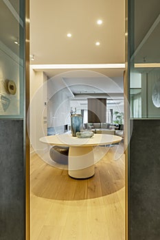 Hallway of luxury home with round table with vases, latticework walls