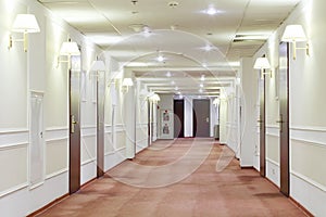 Hallway with many doors leading into hotel rooms. photo