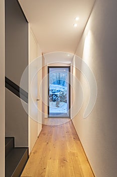 Hallway with white wall and windows with view of nature and snow