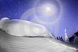 Halo and moon over a snow cornice