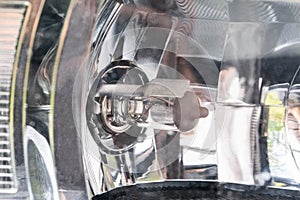 Halogen bulb in headlight with reflector of a passenger car, macro