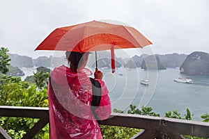 Halong Bay, Vietnam, a girl under an umbrella, stands on the observation deck, admiring the bay