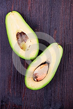 The halved avocados on old wooden table