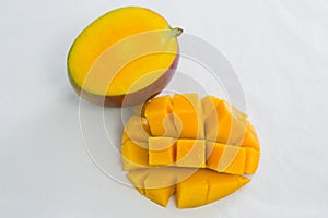 Halved and chopped mango on white background