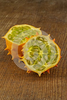 Halved horned melon fruit isolated on wooden board