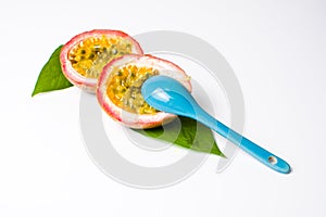 Halved passion fruit with a blue spoon isolated