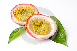 Halved passion fruit with leaves on white