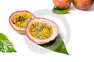 Halved passion fruit with leaves on white