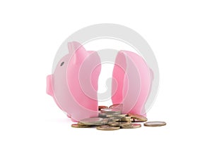Halved pink piggy bank with coins on white background