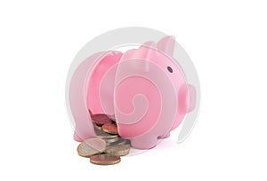 Halved pink piggy bank with coins on white background