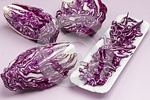 Halved red cabbage, sliced cabbage on on white plate