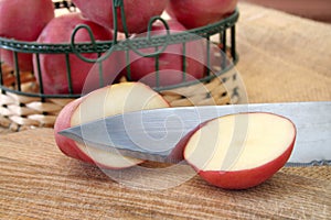 Halved red potato and knife