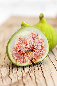 Halved, ripe figs close up on raw, grainy wood