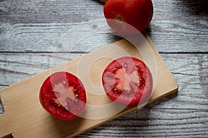 A halved tomato on a chopping board photo