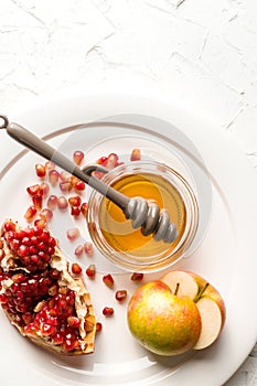 Halves of apples with honey, pomegranate seeds on a large plate