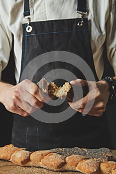 Halves of baguette in the hands of a baker