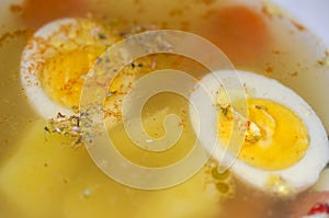 Halves of a boiled egg float in a delicious broth