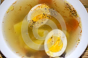 Halves of a boiled egg float in a delicious broth