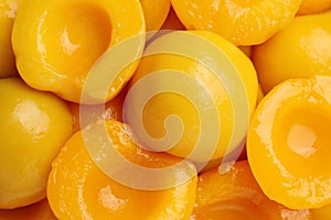 Halves of canned peaches as background, top view