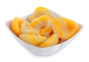 Halves of canned peaches in bowl isolated on white