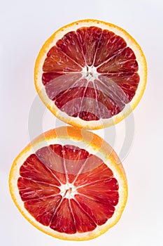 2 halves of a cut blood orange isolated on white