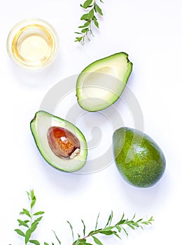 Halves of fresh avocado fruits close up on the white table.