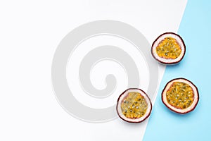 Halves of fresh ripe passion fruits maracuyas on color background, flat lay. Space for text