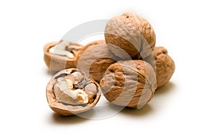 Halves and a pile of walnuts on a white background focus on half