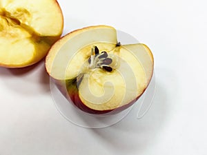 Halves of a red apple. Seeds began to germinate in the body of the apple. Close-up.