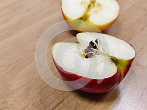 Halves of a red apple. Seeds began to germinate in the body of the apple. Close-up.